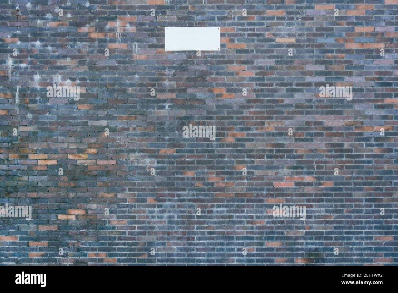 Mur en brique rouge et noire avec une affiche vierge Banque D'Images