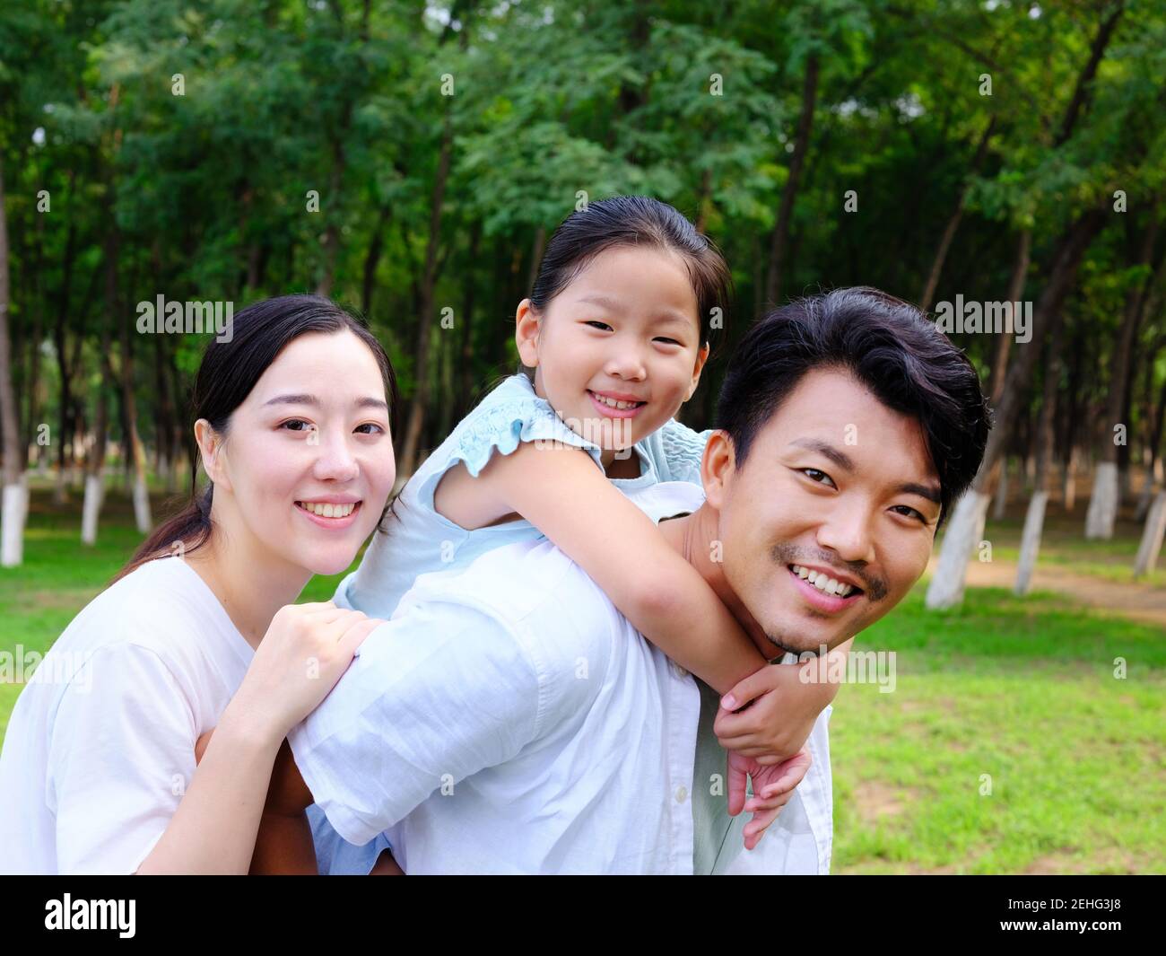 Une famille heureuse de trois personnes jouant dans le parc souriant Banque D'Images