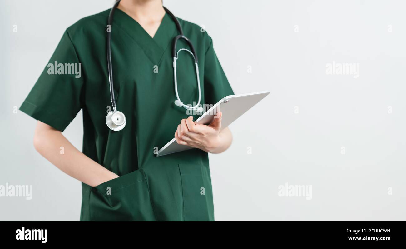 Le médecin se tient sur fond blanc avec un stéthoscope et une tablette numérique. Banque D'Images