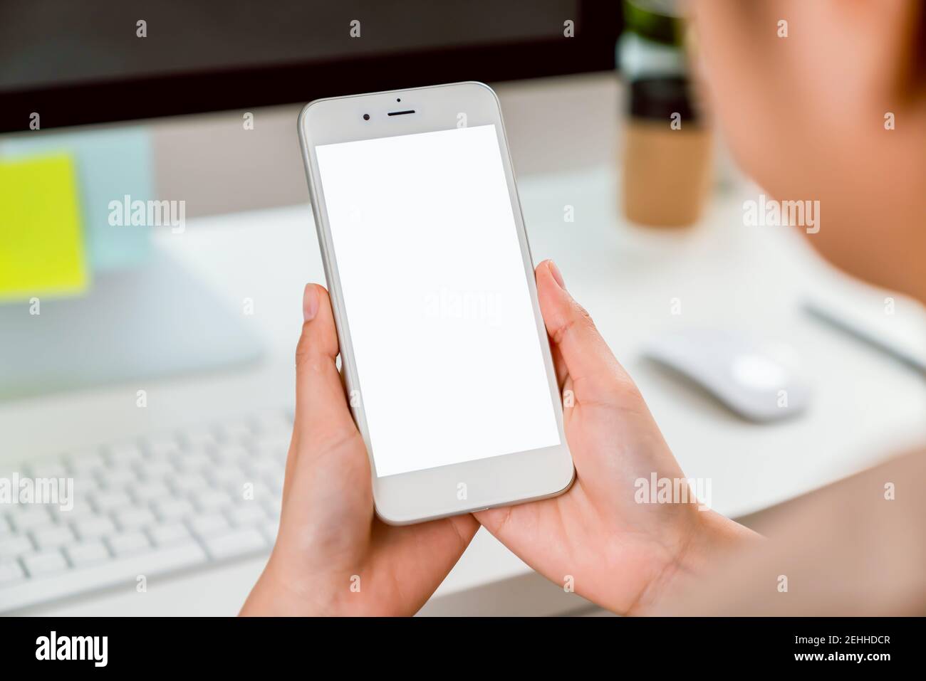 Main tenant le smartphone maquette d'écran vide sur la table. Prenez votre écran pour mettre sur la publicité. Banque D'Images