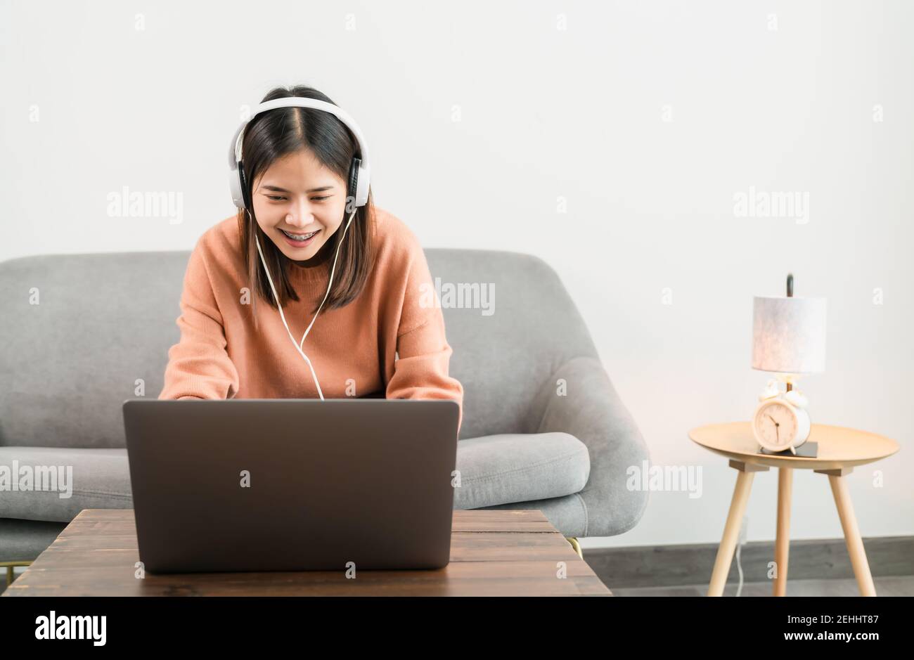 Smiley asiatique jeune femme utilisant un ordinateur portable à la table, étudier en ligne sur Internet et appel vidéo avec des enseignants et des amis. Banque D'Images