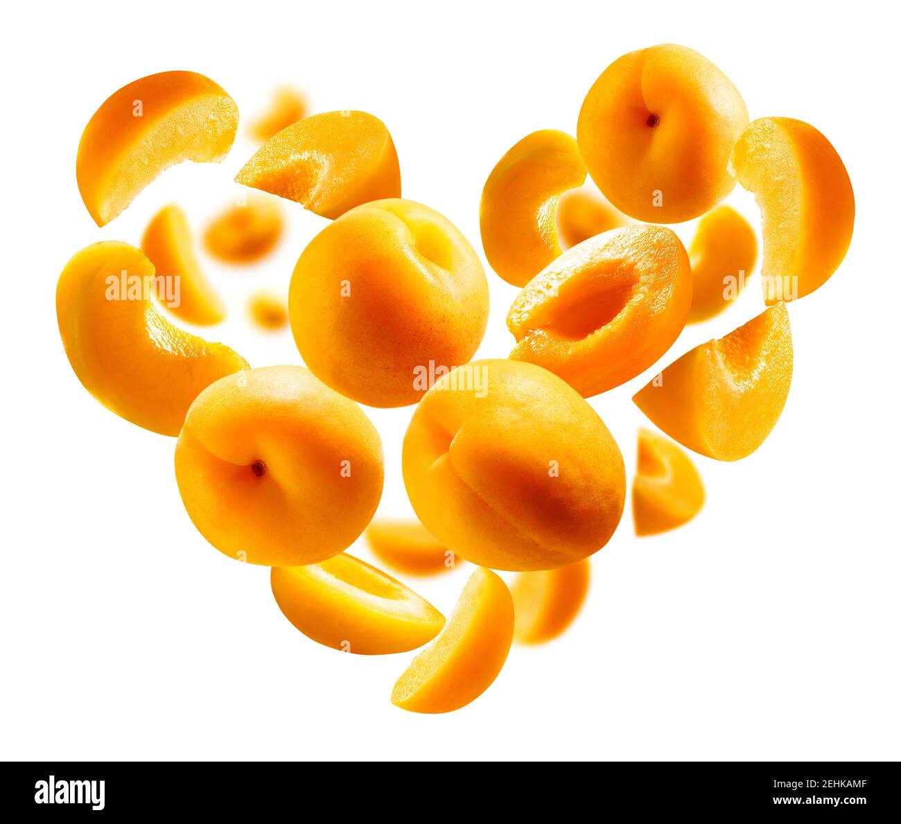 Abricots en forme de coeur sur fond blanc. Fruits mûrs en vol Banque D'Images