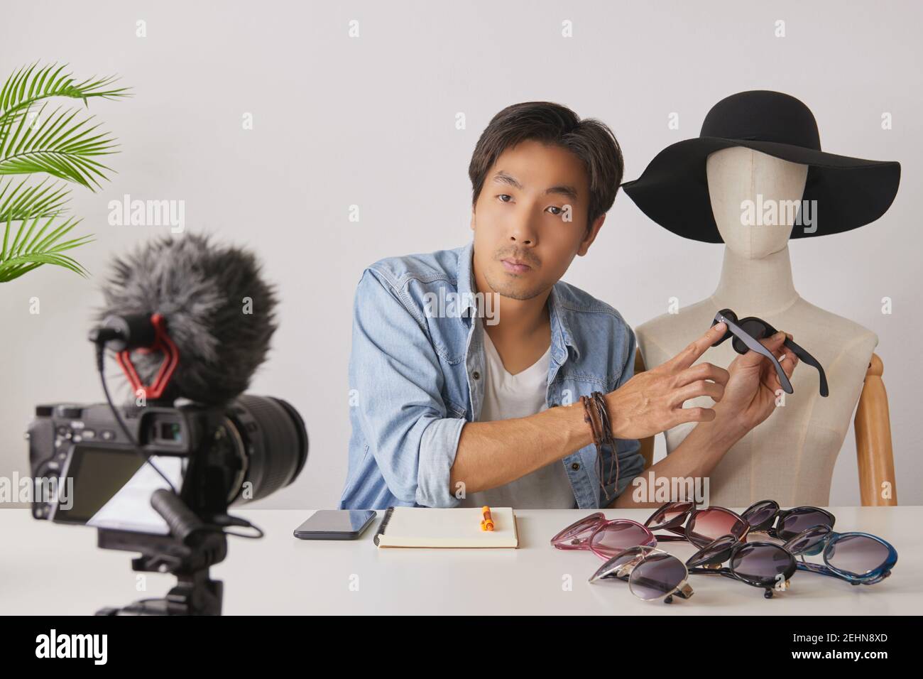 Vlogger asiatique ou Blogger en chemises Jean avec mannequins point Fashion lunettes et enregistrement vidéo. Freelance Online Streaming avec le client via Banque D'Images