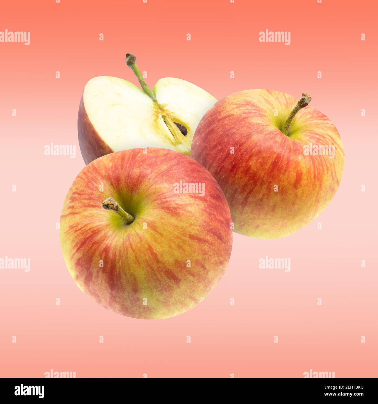 Voler rouge frais entier et couper les pommes sur fond rose. Banque D'Images