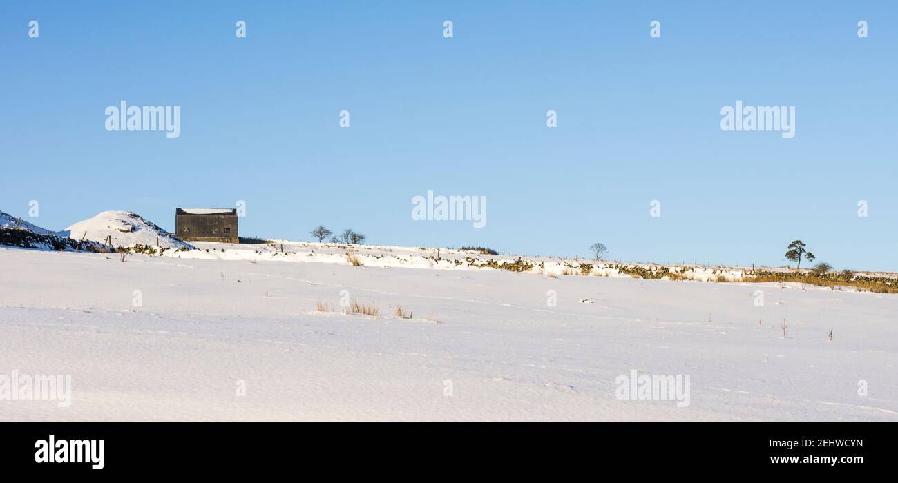 Une grange noire et une mine de butin vue sur un champ de neige dans les Pennines du Nord, Weardale, comté de Durham Banque D'Images