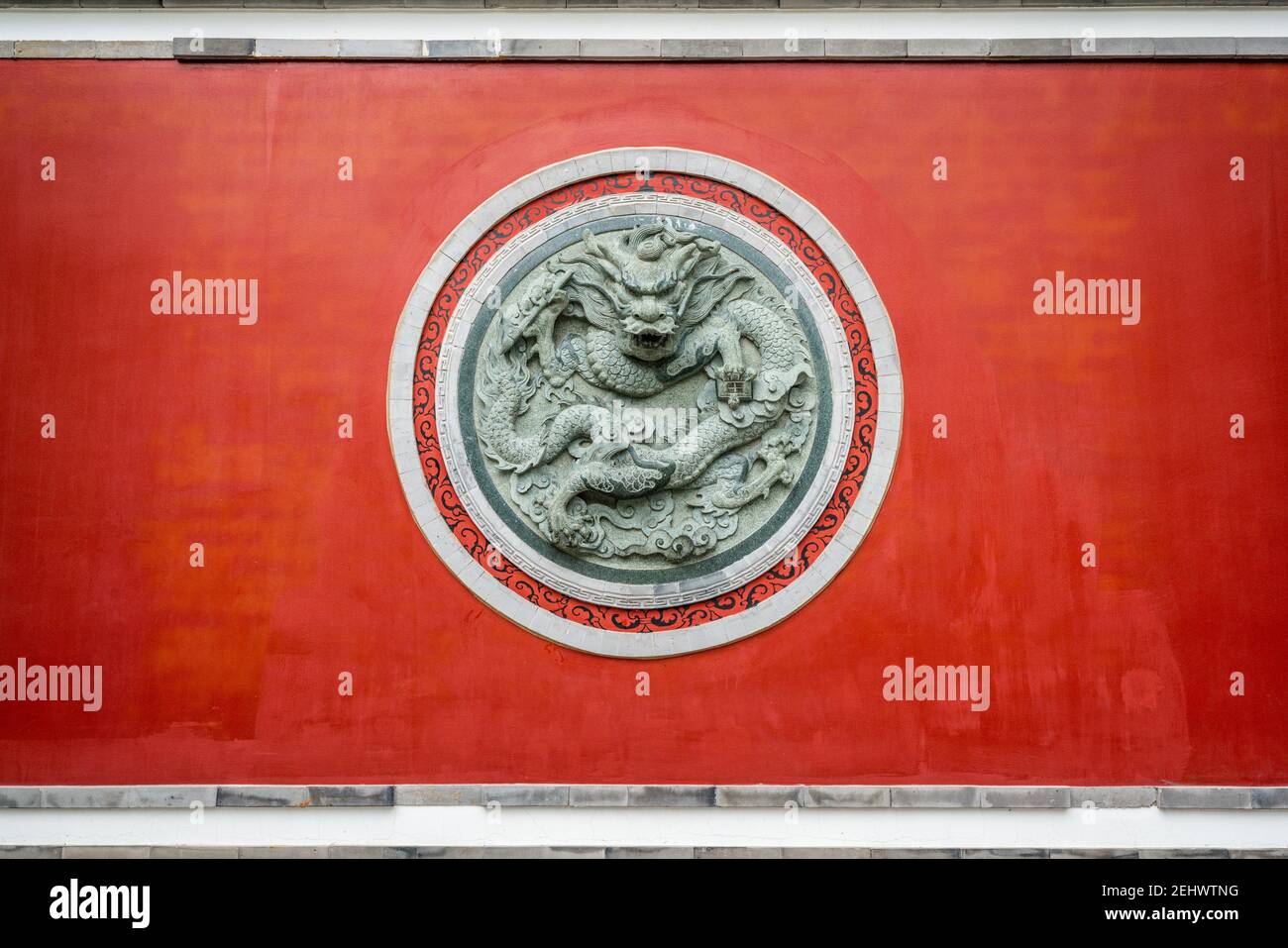 Mur rouge avec sculpture circulaire dragon au temple confucianiste De la vieille ville de Dali dans Dali Yunnan Chine Banque D'Images