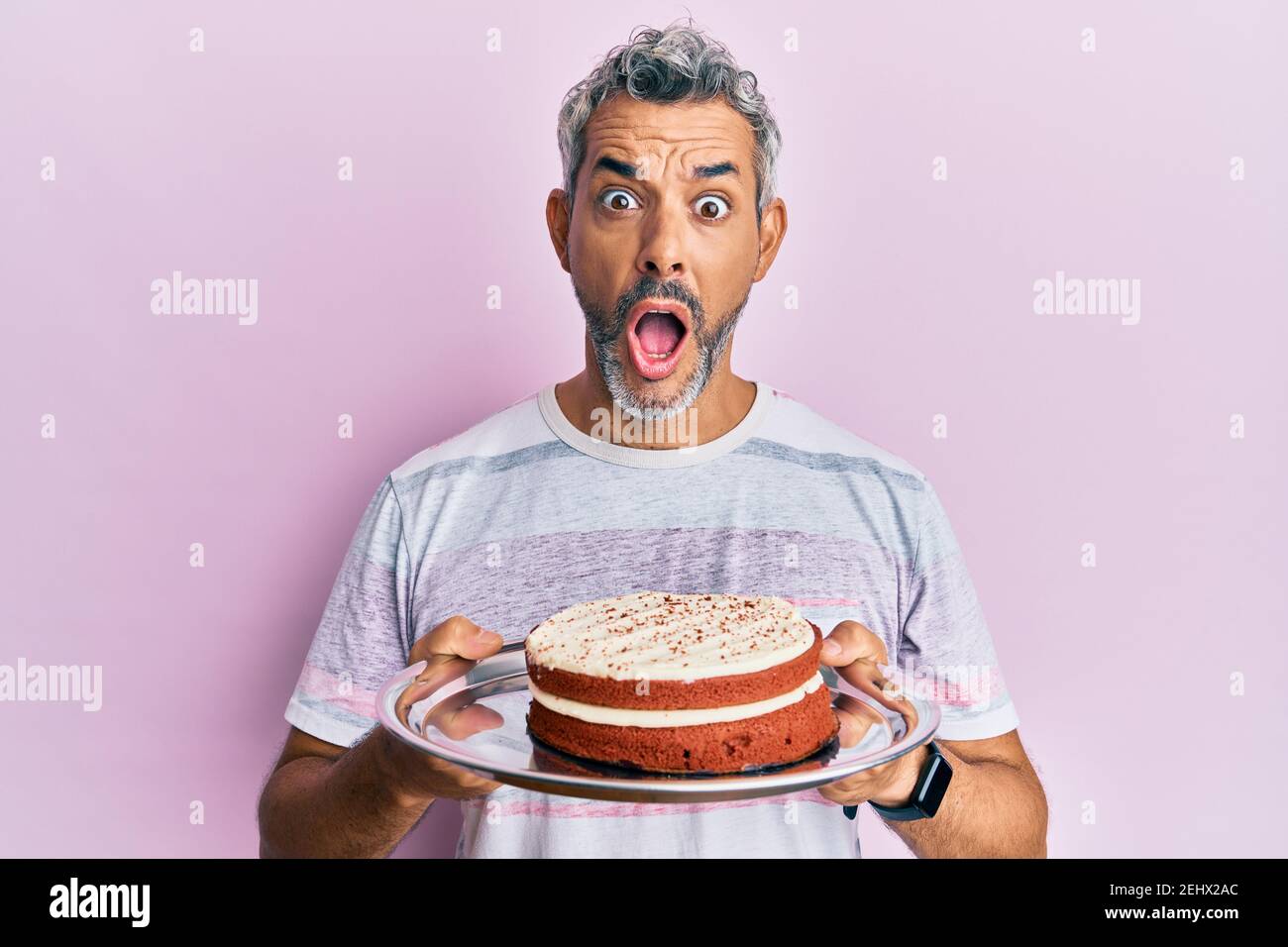 Homme Mi Age A Poil Gris Tenant Un Gateau De Carotte Peur Et Choque Avec Une Expression Surprise Et Stupefaite Peur Et Visage Excite Photo Stock Alamy
