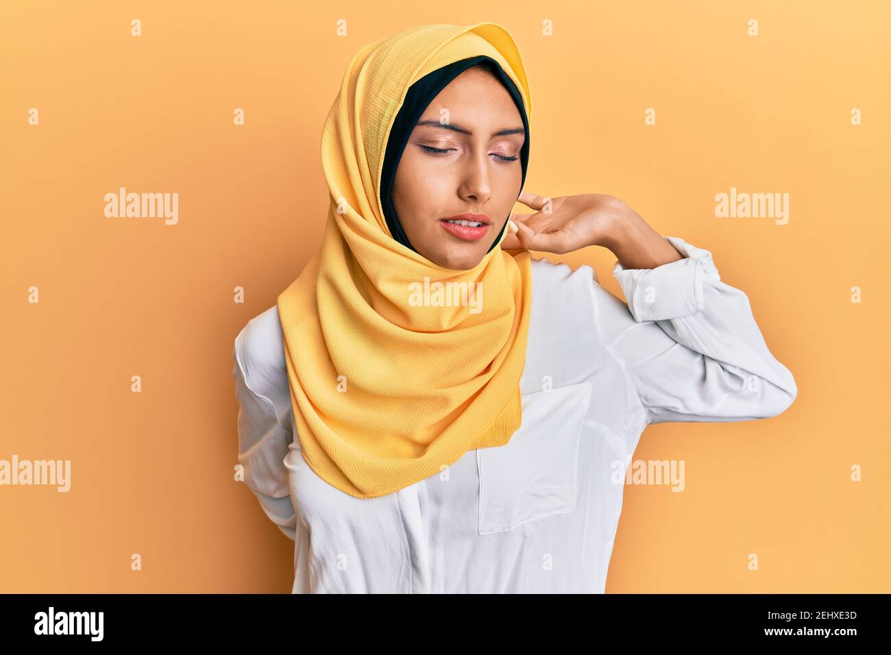 Jeune femme arabe brune portant un foulard islamique traditionnel hijab  s'étirant vers le dos, fatiguée et détendue, endormie et bâillonnante tôt  le matin Photo Stock - Alamy