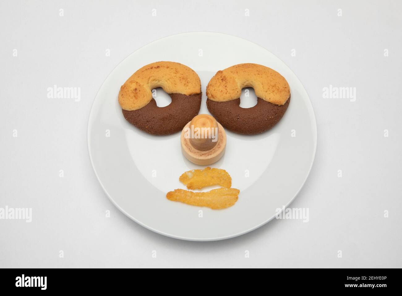 un visage fait de biscuits sur une assiette avec cornflex bouche Banque D'Images