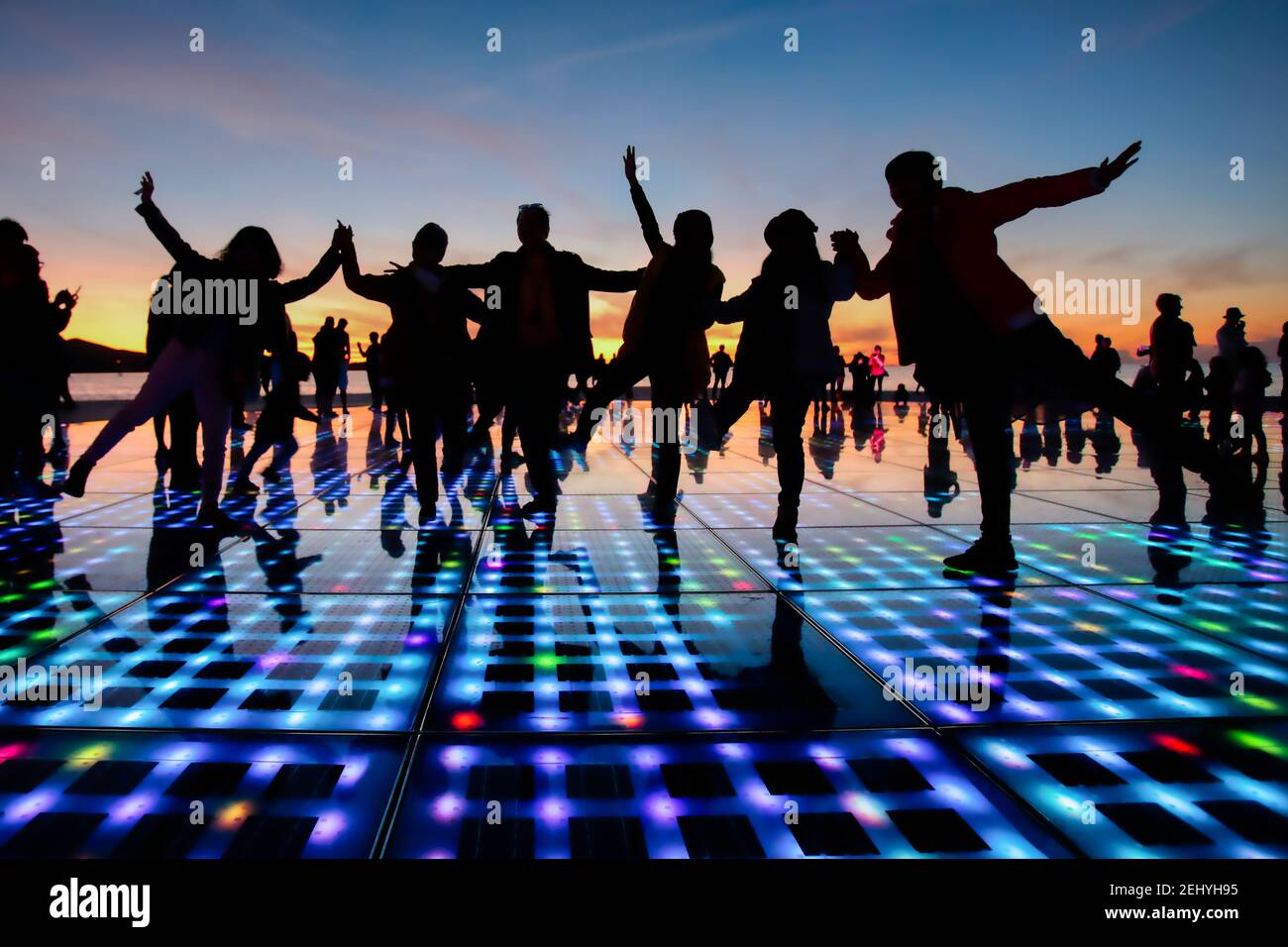 Zadars salutation à l'installation du spectacle lumineux Sun avec des silhouettes de Les gens dansent sur elle et coucher de soleil en arrière-plan Banque D'Images