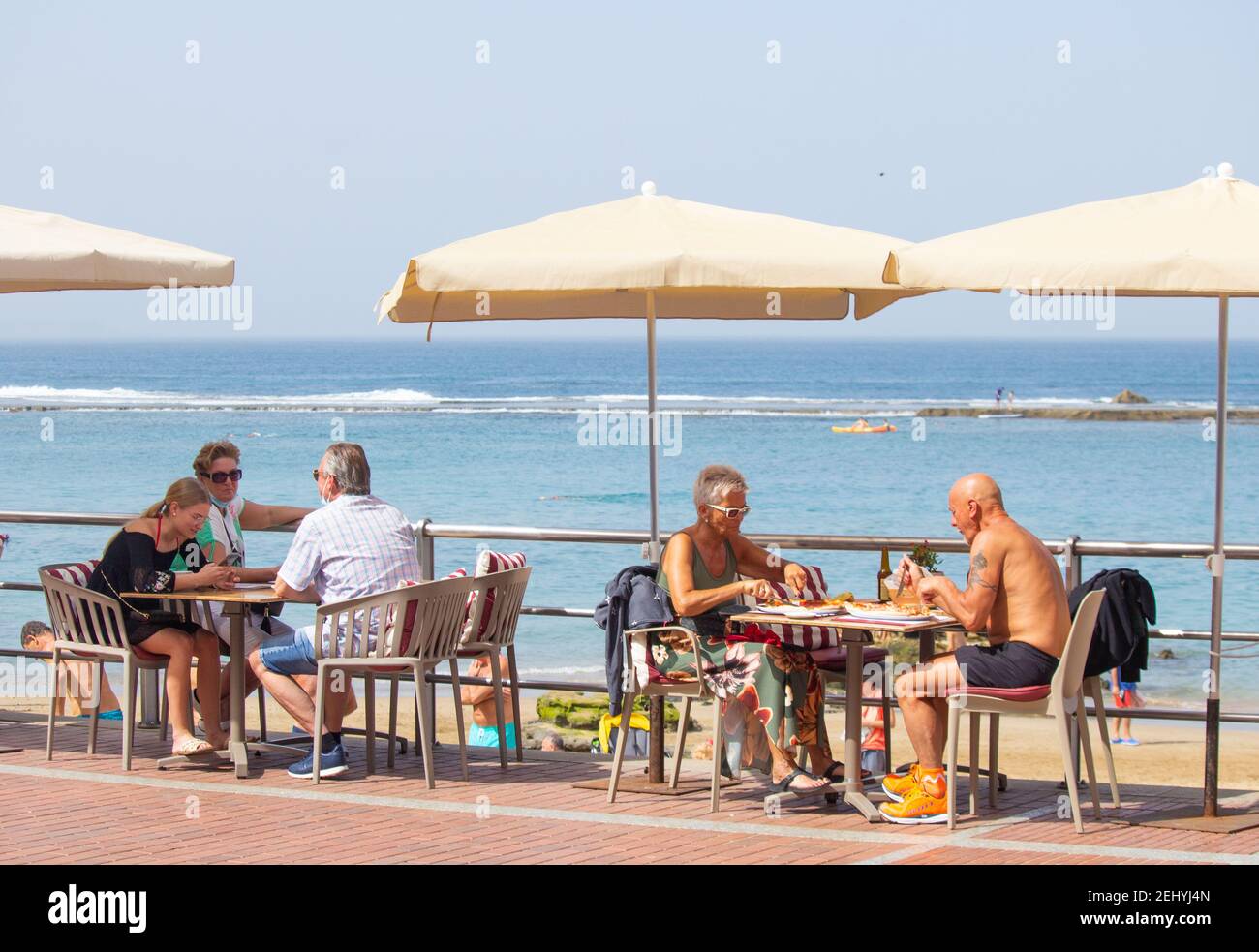 Las Palmas, Grande Canarie, Îles Canaries, Espagne. 20 février 2021. Les habitants et les touristes curieux pack la plage de la ville à Las Palmas sur Gran Canaria comme le plume de poussière sahraouie se dégage lentement des îles Canaries. Le panache d'air du Sahara, qui s'étend vers le nord, va voir la température augmenter aussi loin au nord que le Royaume-Uni Credit: Alan Dawson/Alay Live News. Banque D'Images