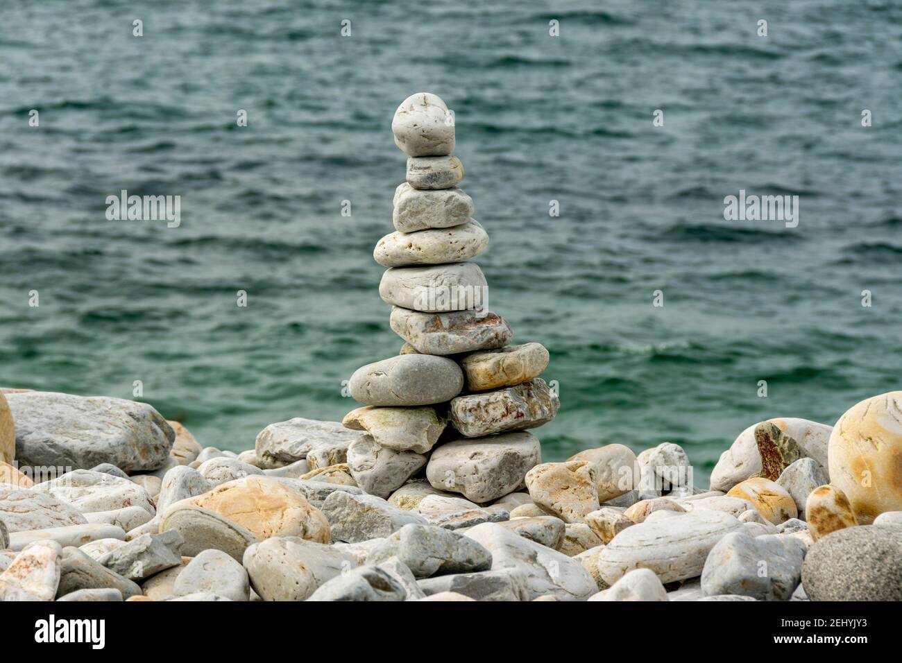 Tour de pierre créée en équilibrant des galets sur un rivage tranquille pendant les heures de lumière du jour Banque D'Images