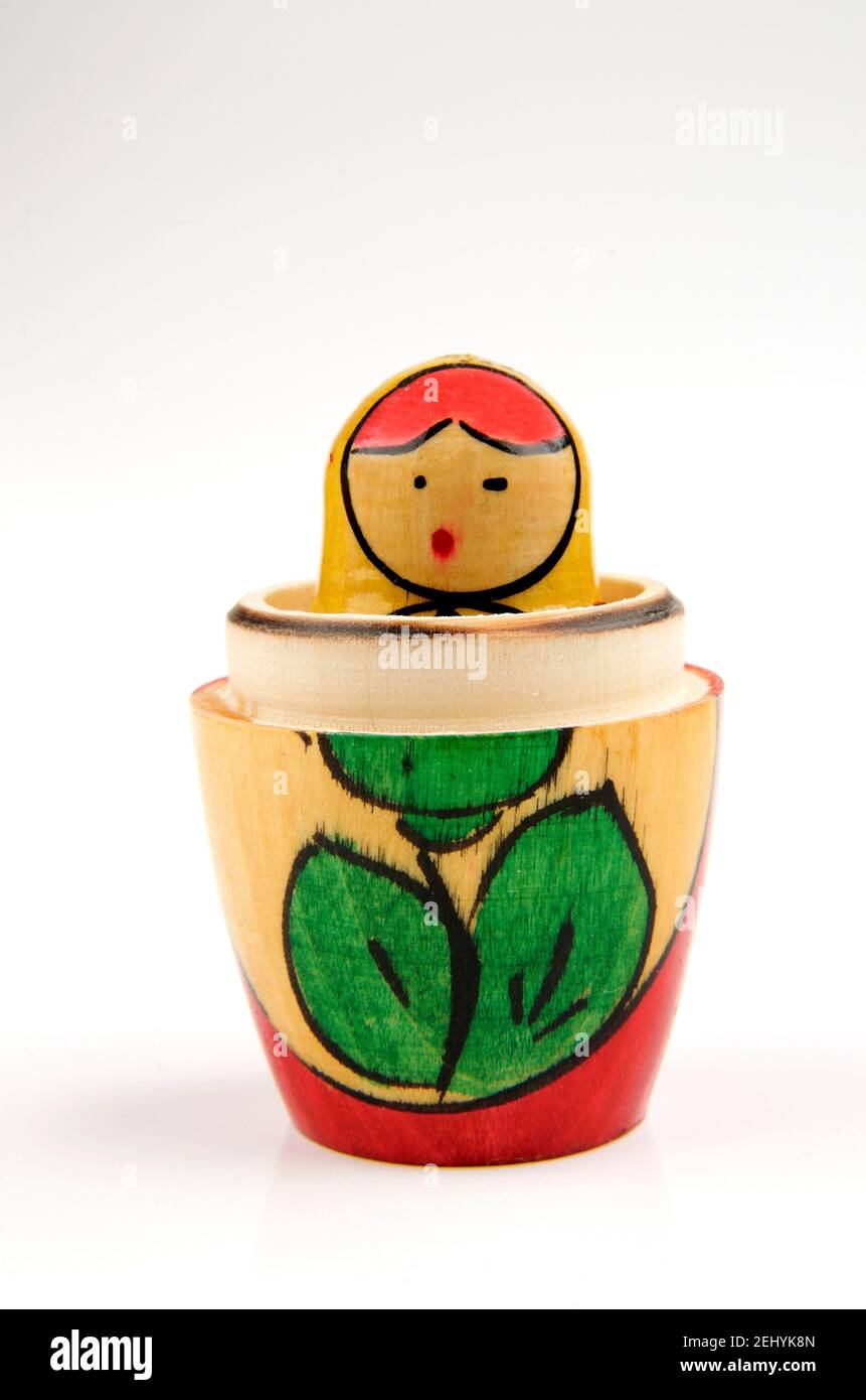 Poupée nichoir en bois avec motif floral peint et couleurs vives placées sur un fond Uni Banque D'Images