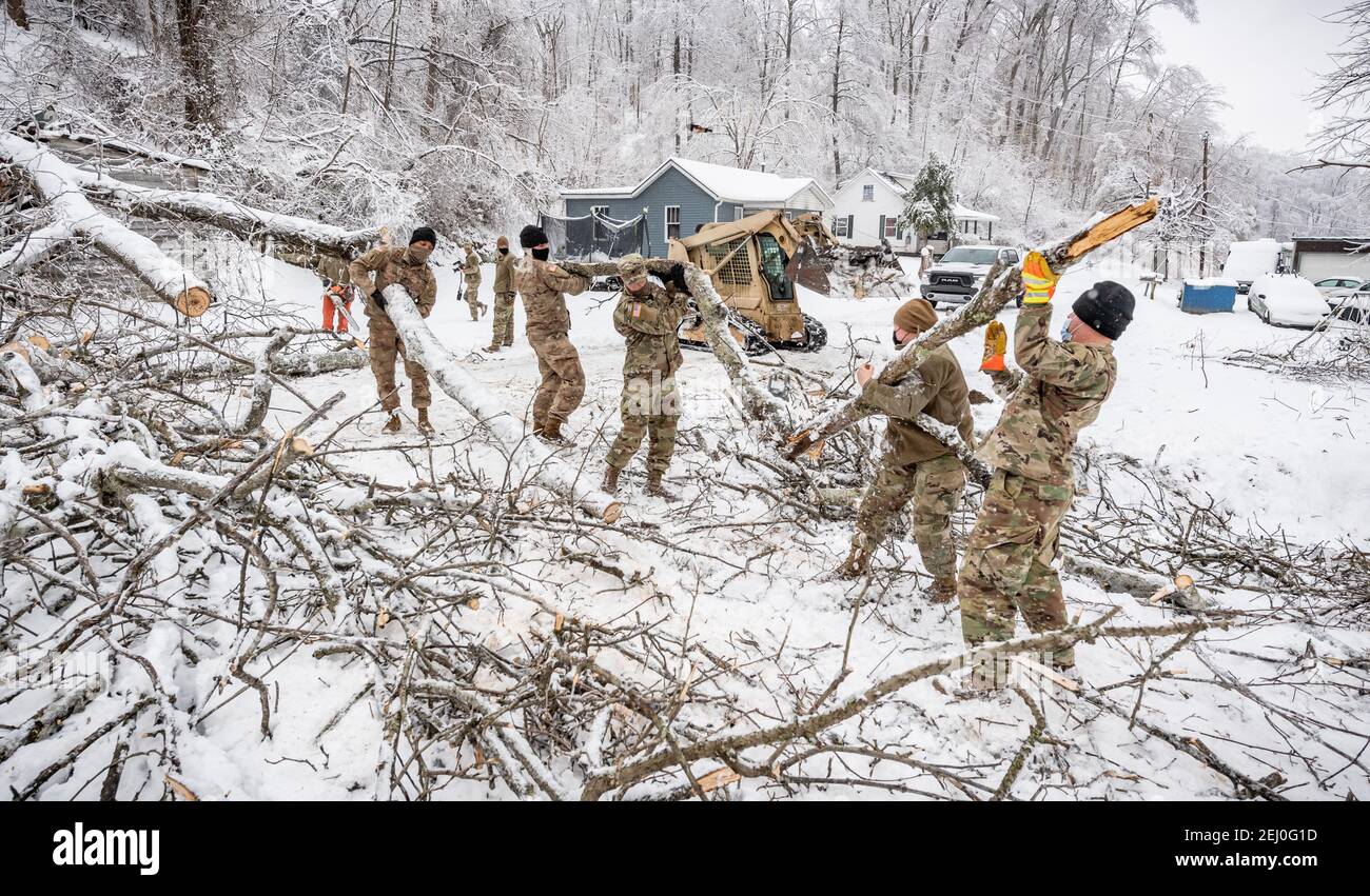 Ceredo, États-Unis. 19 février 2021. Les soldats américains de la Garde nationale de Virginie-Occidentale dépovent les débris d'une tempête d'hiver au large d'une route le 19 février 2021 à Ceredo, dans le comté de Wayne, en Virginie-Occidentale. Plus tôt dans la semaine, un grand système de tempête d'hiver a laissé plus de 90,000 Virginie occidentale sans électricité dans toute la région, faulant les arbres et rendant les routes éloignées impraticables. Credit: Planetpix/Alamy Live News Banque D'Images