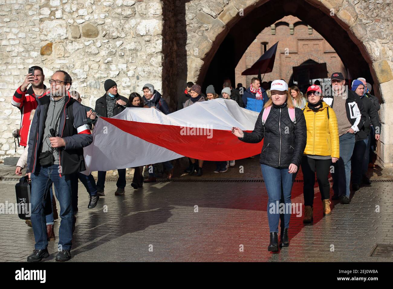 Cracovie, Pologne : février 20 2021: Manifestation appelée MARCHE VERS LA LIBERTÉ dans le centre-ville de Cracovie, les gens ont le grand drapeau national polonais, protes Banque D'Images