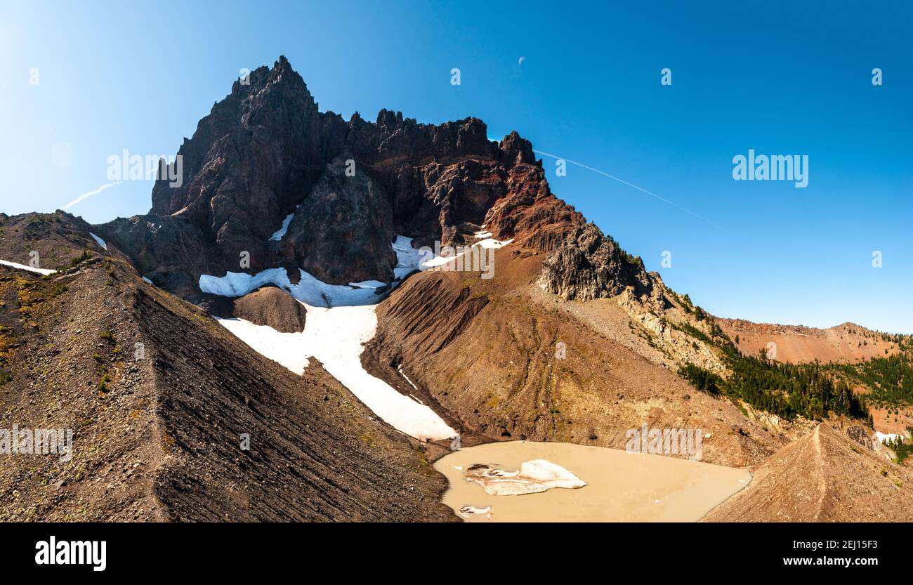 Le croissant de lune s'amenuise au-dessus du Three Finger Jack de l'Oregon avec un petit lac glaciéal dans le cirque au-dessous du sommet. Banque D'Images
