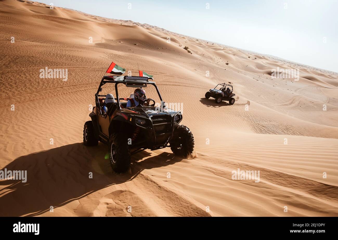 Deux voitures en quad se trouvent sur les collines de sable d'Al Awir  (Aweer) avec drapeaux emirates, divertissement touristique de luxe,  aventures en véhicule motorisé Photo Stock - Alamy