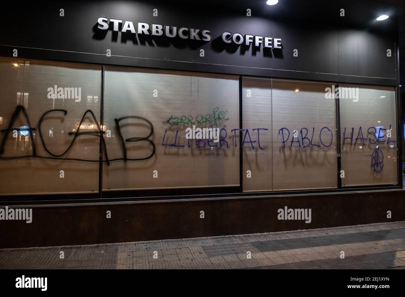 Un graffiti appelant à la liberté de Pablo Hasel est visible sur la fenêtre de la cafétéria du café Starbucks. Cinquième nuit de manifestations et d'émeutes en réponse à l'arrestation et à l'emprisonnement du rappeur Pablo Hasel accusé d'exalter le terrorisme et d'insulter la couronne pour le contenu des paroles de ses chansons. Banque D'Images
