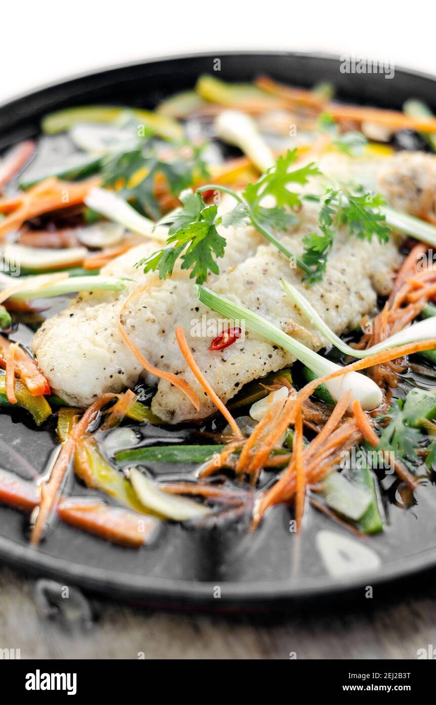 filet de poisson épicé chinois à la vapeur de style cantonais accompagné de légumes plaque chaude Banque D'Images