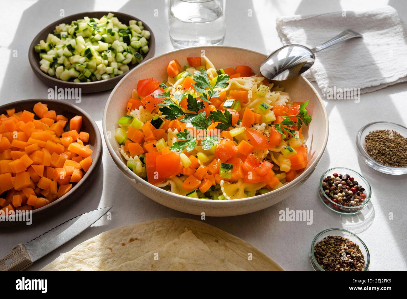 Assiette de légumes avec carottes, courgettes et pâtes, assaisonnées d'épices Banque D'Images
