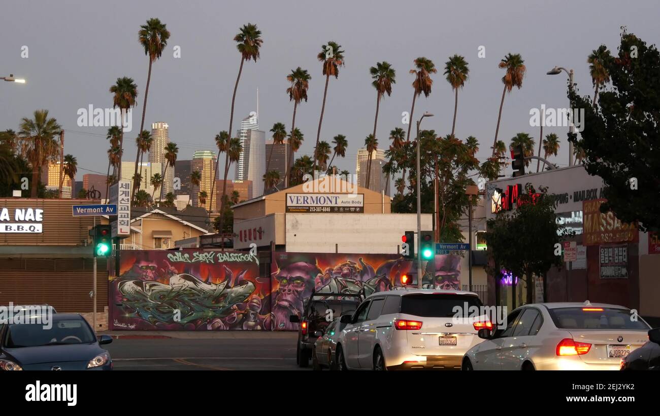 LOS ANGELES, CALIFORNIE, États-Unis - 30 octobre 2019 : gratte-ciel et palmiers urbains. LA ville nuit esthétique, graffiti peinture sur la rue Vermont. Gratte-ciel en hauteur Banque D'Images