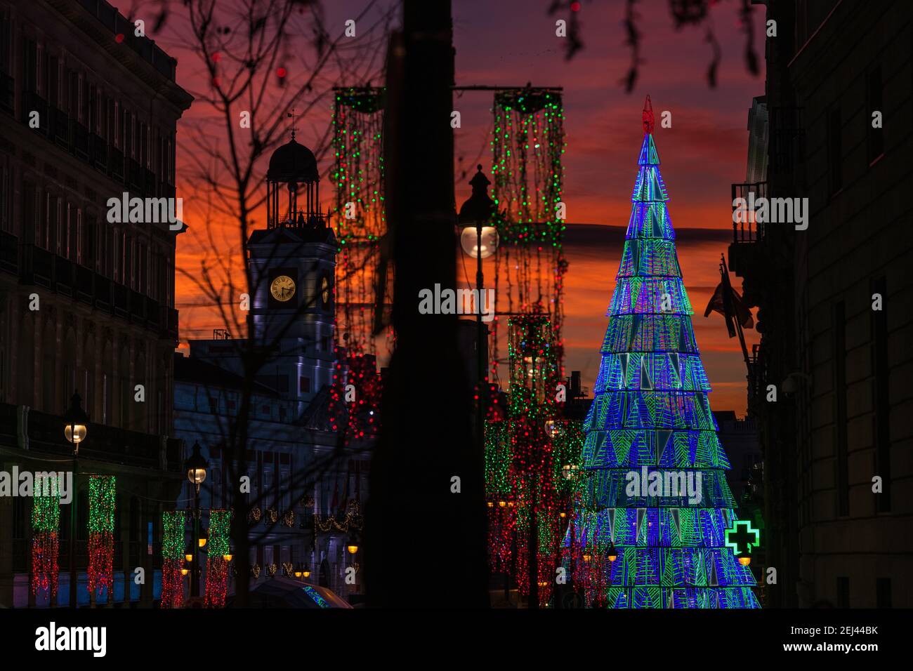 Arbre de Noël illuminé s'élevant au centre de la place Puerta del sol à Madrid au crépuscule. Banque D'Images