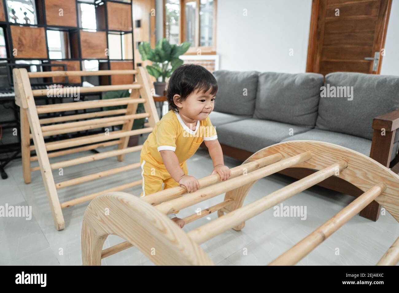 Mignon Bebe Escalade Sur Pikler Triangle Jouets Dans La Vie Chambre Photo Stock Alamy