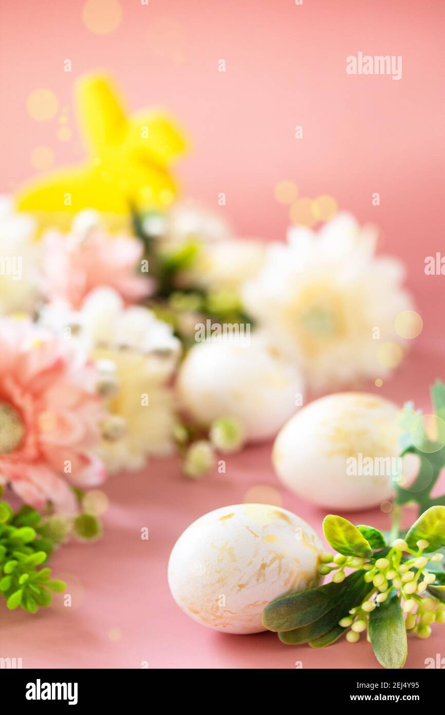 Fond floral de Pâques. Fleurs de printemps gerbera avec des oeufs de pâques sur fond rose. Copier l'espace. Banque D'Images