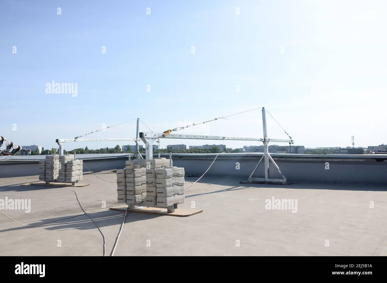 Contrepoids ou contrepoids blocs de béton ou briques en tant que partie de la plate-forme de corde de fil suspendu pour les travaux de façade sur de hauts bâtiments à plusieurs étages. Homme Banque D'Images