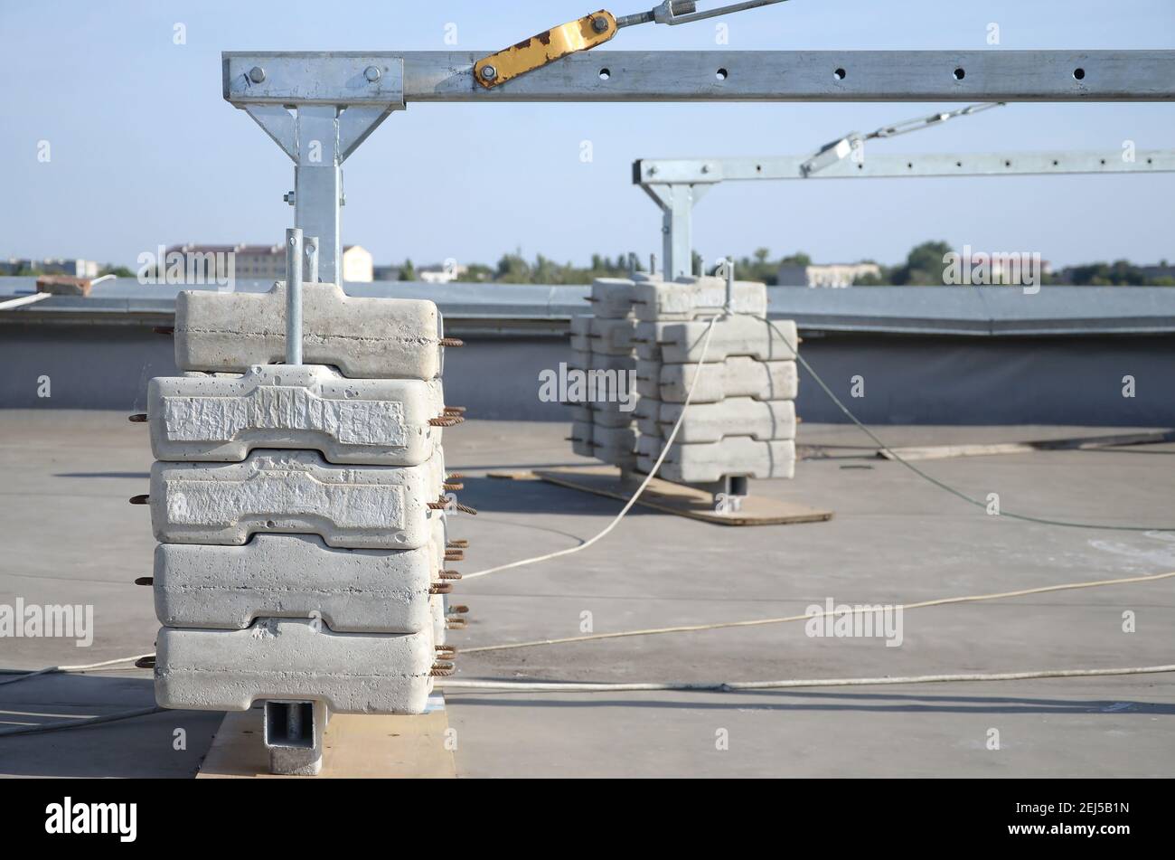 Contrepoids ou contrepoids blocs de béton ou briques en tant que partie de la plate-forme de corde de fil suspendu pour les travaux de façade sur de hauts bâtiments à plusieurs étages. Homme Banque D'Images