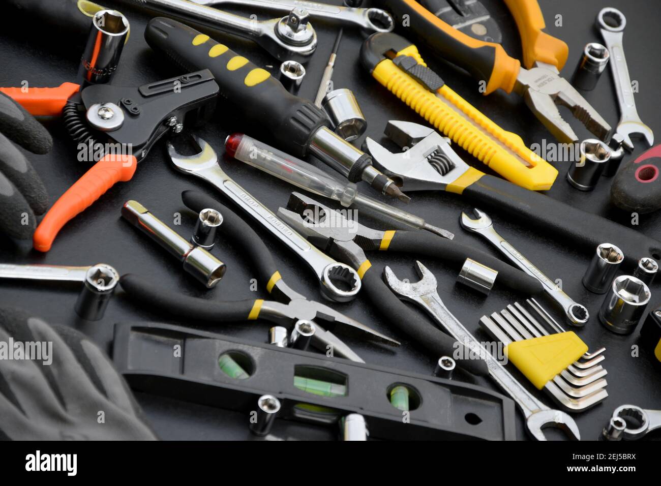 Kit d'outils pour homme à main sur table en bois noir. Beaucoup de clés et  de tournevis, pilers et autres outils pour tout type de réparation ou de  construction. Réparation Photo Stock -