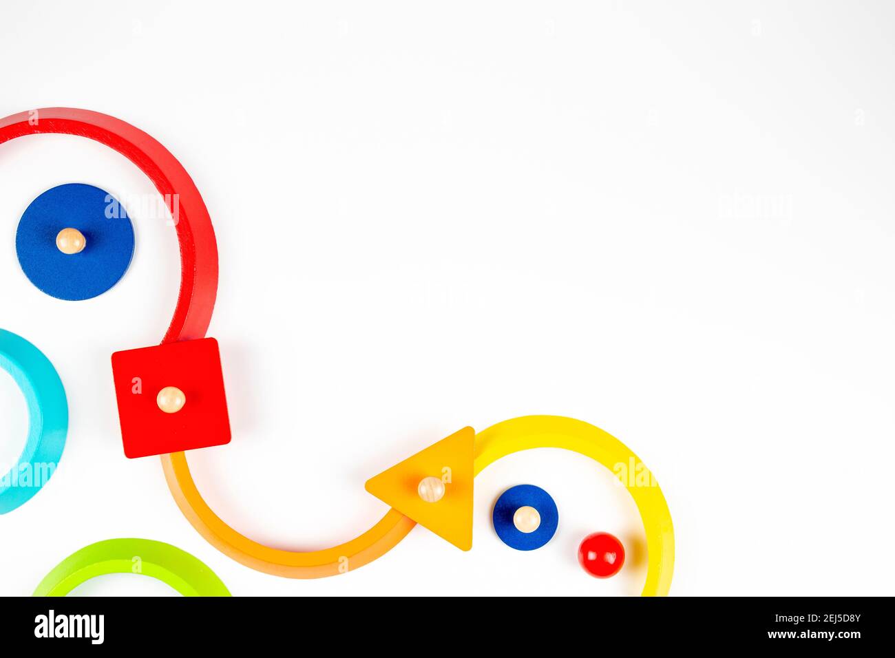Formes géométriques en bois figurines de jeu colorées composition sur fond blanc. Vue de dessus Banque D'Images