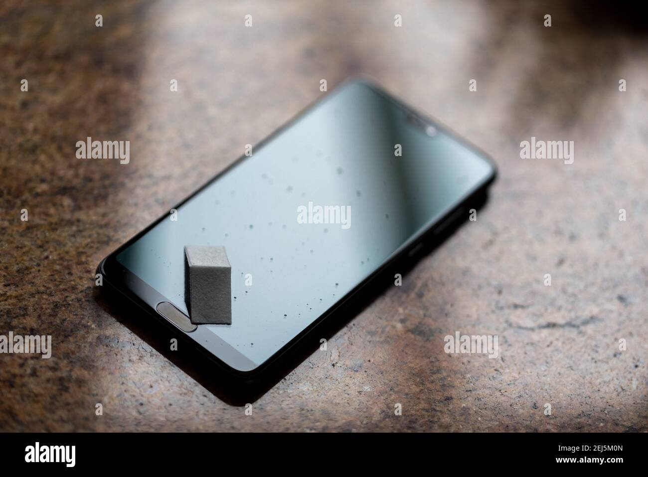 Écran de smartphone en verre trempé pour une protection contre les rayures. De l'eau s'infiltre sur l'écran. Nettoyage de l'écran tactile. Banque D'Images