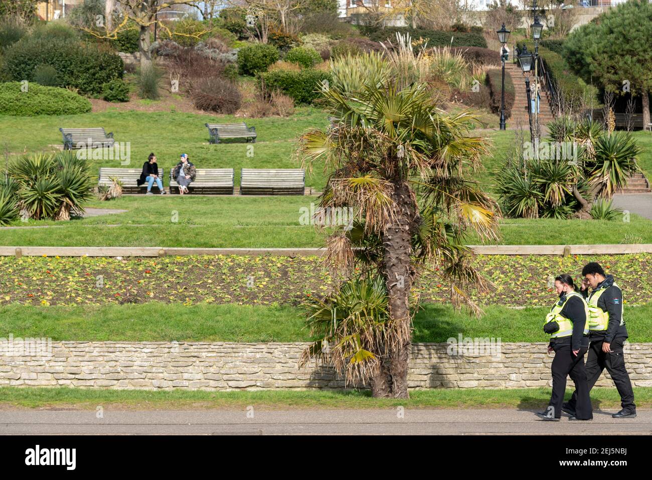 Des gardes de sécurité communautaires patrouillent à Southend sur la mer, Essex, Royaume-Uni, lors d'une journée ensoleillée, pendant le confinement de la COVID 19, avec des gens qui apprécient les jardins Banque D'Images