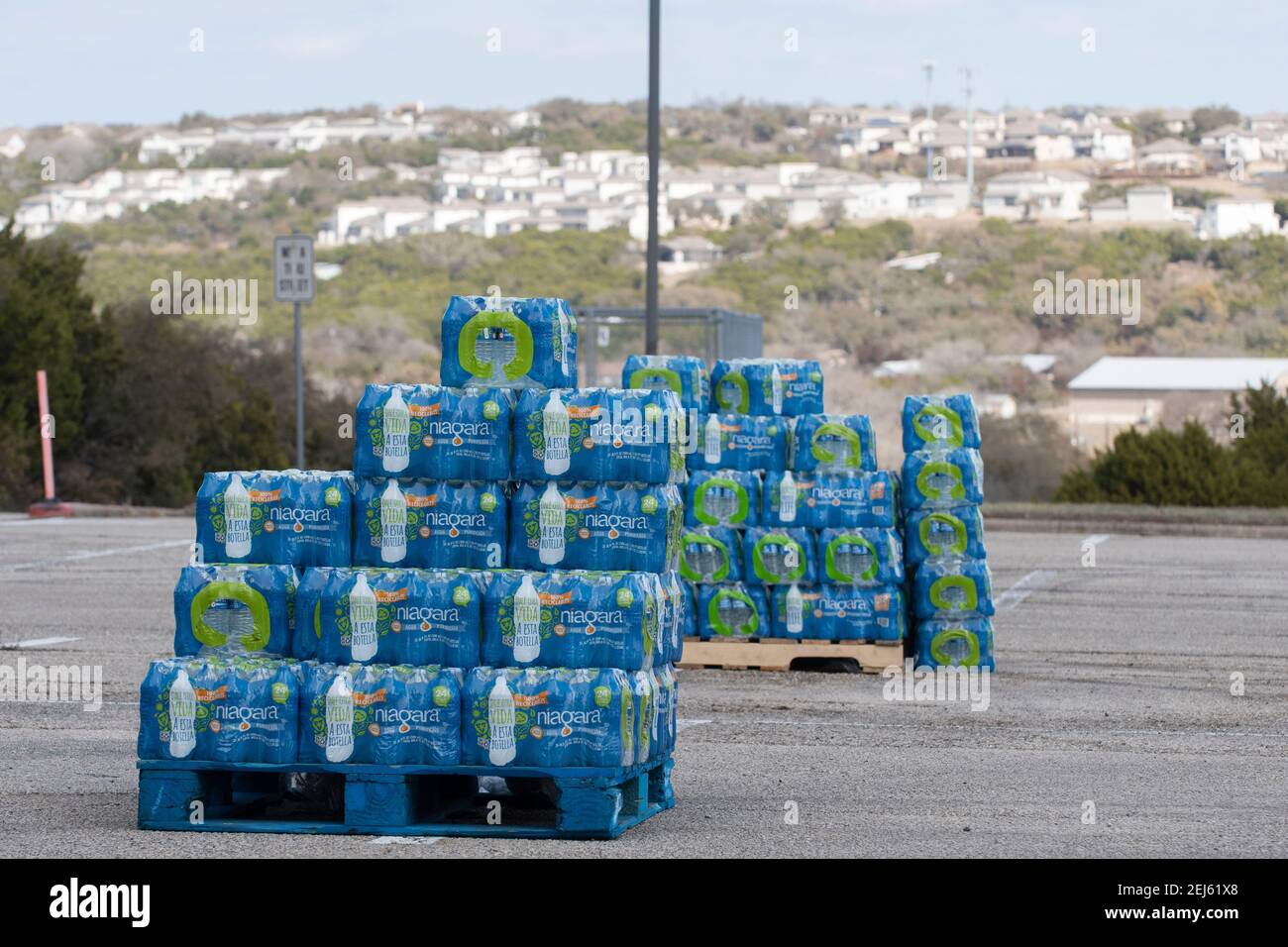 Oak Hill, TX USA 21 février 2021 : caisses d'eau en bouteille sur des palettes prêtes à être transmises à l'ouest du comté de Travis désespéré, résidents du Texas hors de l'eau du robinet pendant plusieurs jours en raison de la tempête de neige dévastatrice du Texas la semaine dernière. Les conducteurs n'ont été autorisés qu'un seul cas par voiture après que certains aient attendu trois heures en file d'attente. Crédit : Bob Daemmrich/Alay Live News Banque D'Images