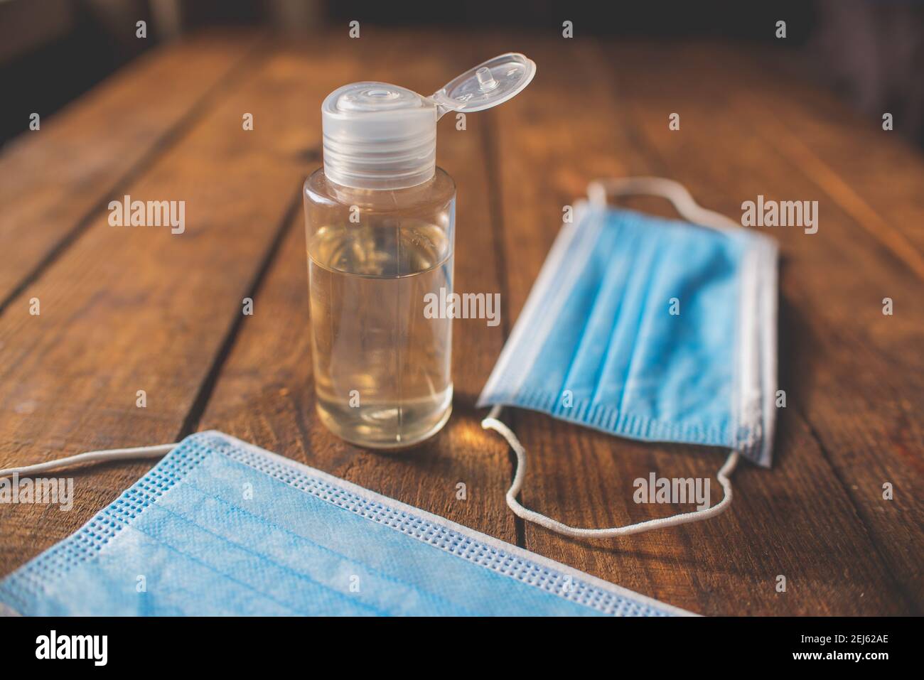 bouteille en plastique avec désinfectant pour les mains et masques jetables une table en bois Banque D'Images
