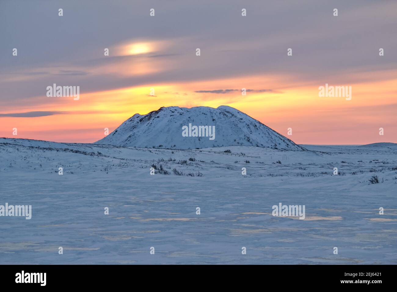 Un site emblématique de Pingo (colline à corées de glace à l'intérieur du pergélisol) au coucher du soleil dans le paysage hivernal arctique près de Tuktoyaktuk, Territoires du Nord-Ouest, Canada Banque D'Images