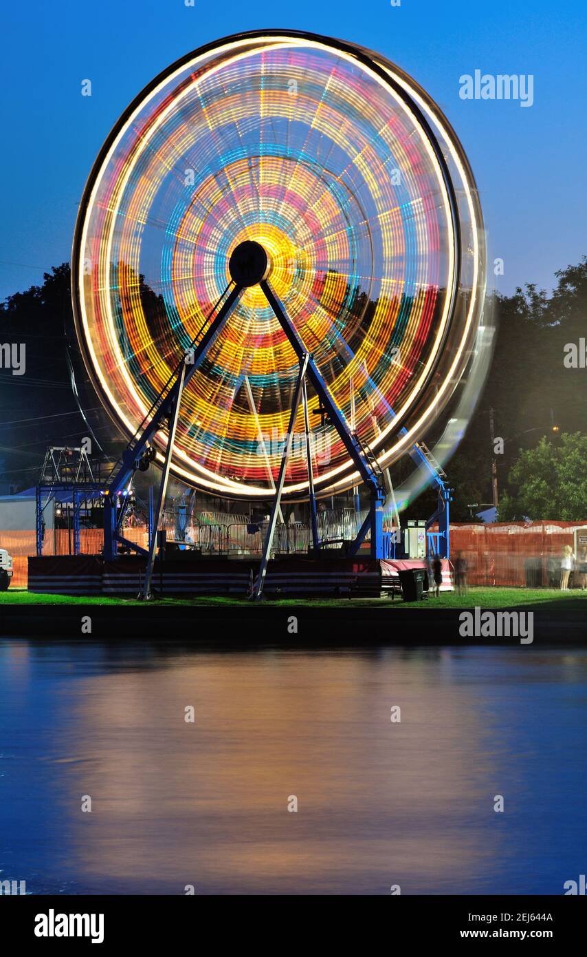 South Elgin, Illinois, États-Unis. Une grande roue à un petit carnaval d'été communautaire est un flou de lumière. Banque D'Images