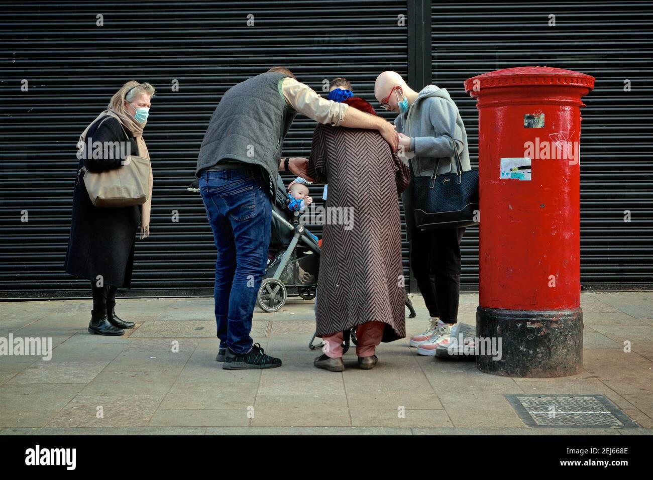 Deptford High Street - Londres (Royaume-Uni), 21 février 2021 : une femme est réconfortée et aidée par des passants concernés pendant la pandémie de covid . Banque D'Images