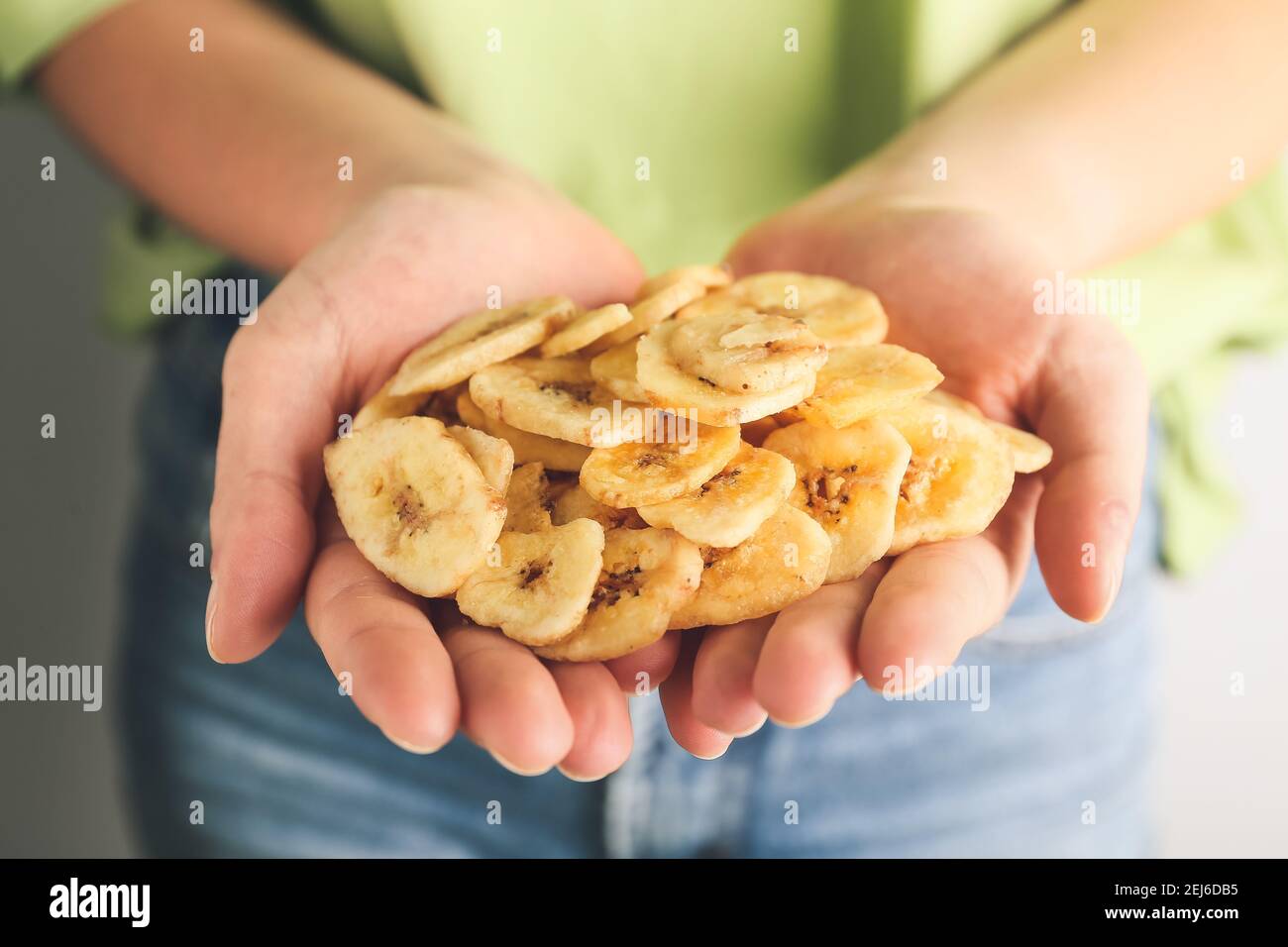 Femme tenant des chips de banane, gros plan Banque D'Images