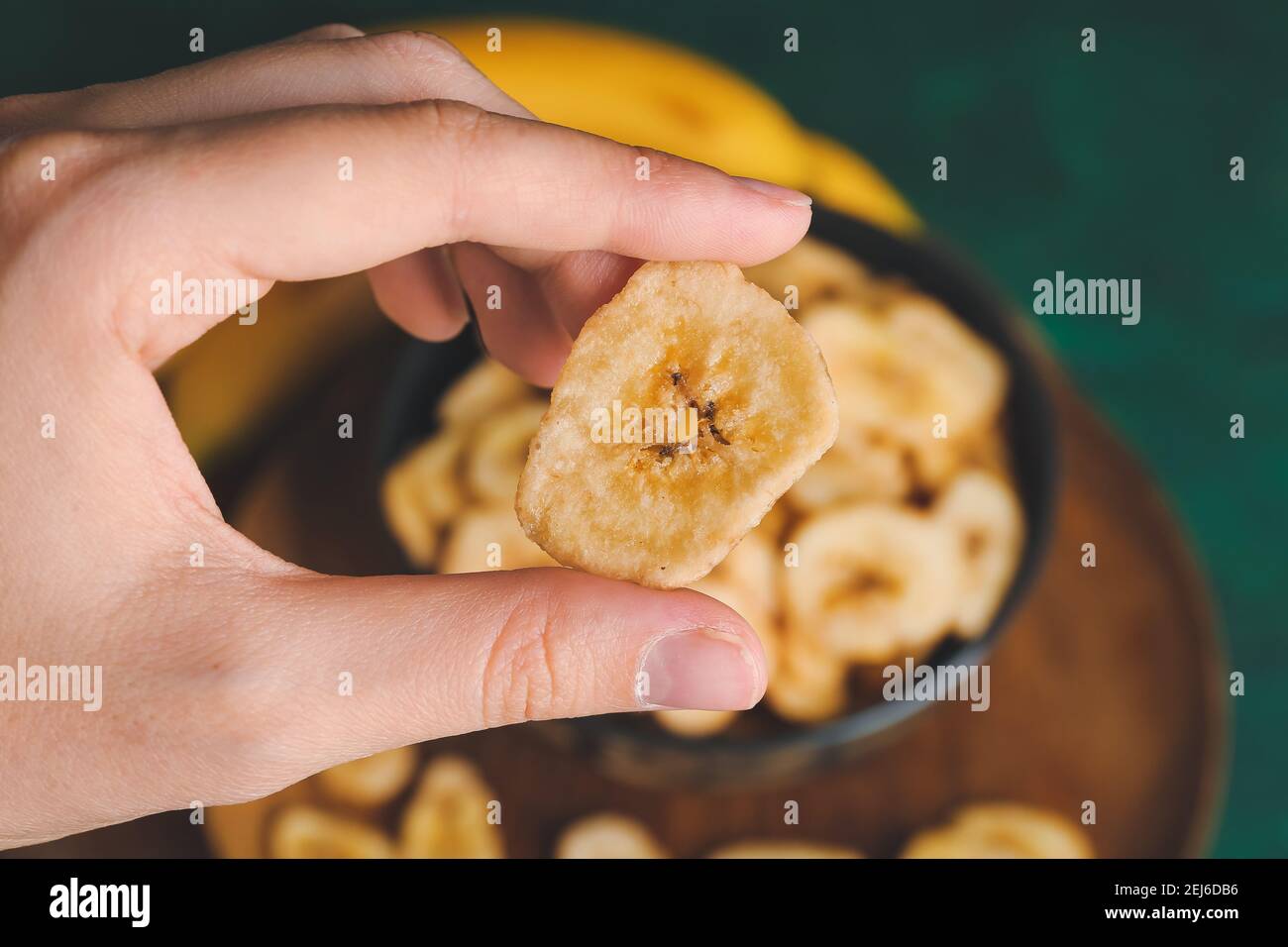 Femme tenant des chips de banane, gros plan Banque D'Images