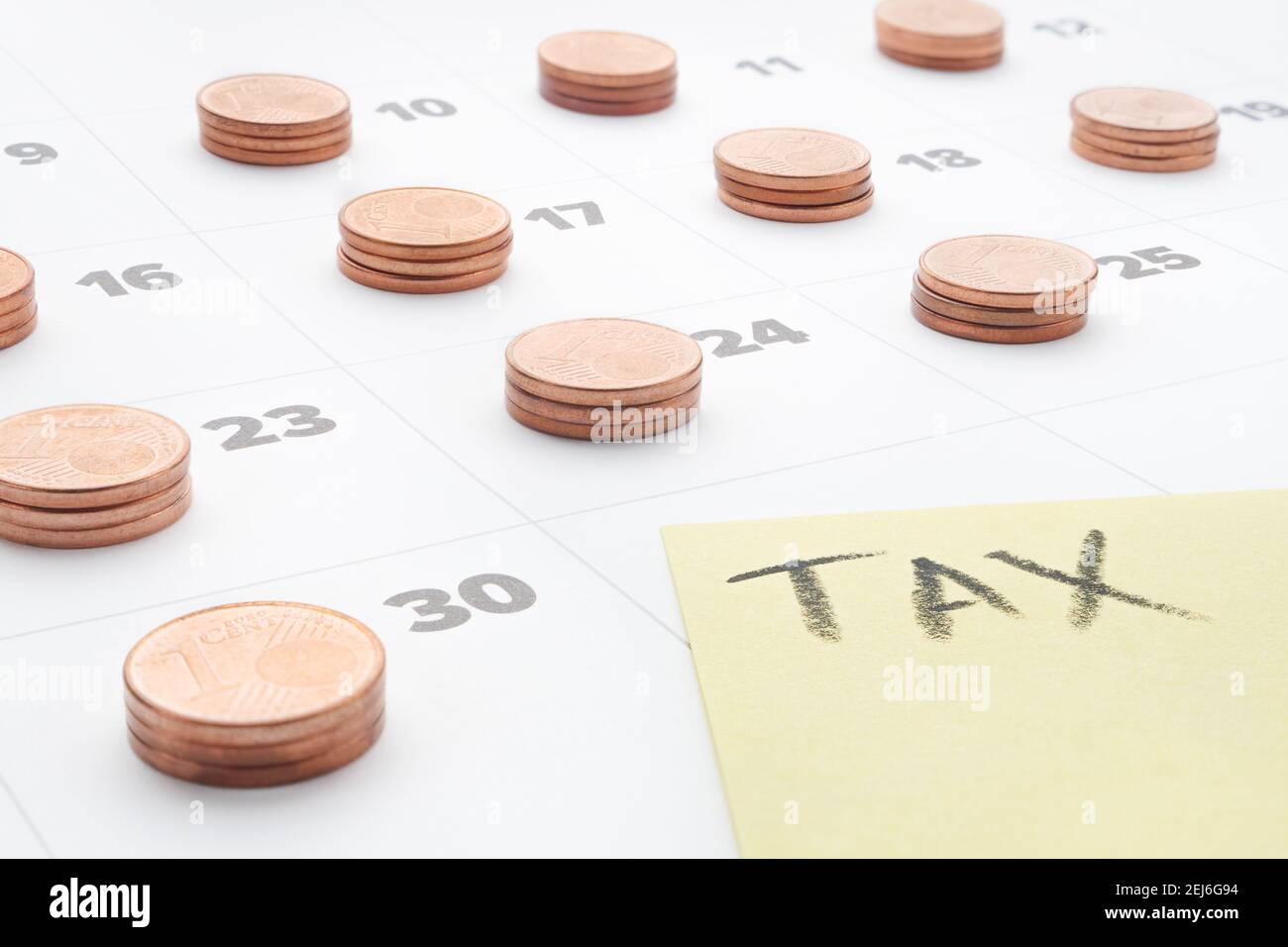 Euro monnaie planification fiscale budget des services publics des ménages calendrier comptabilité fiscale. Taxe sur les mots inscrite sur une note en papier jaune avec des piles de pièces en euros le dernier jour Banque D'Images