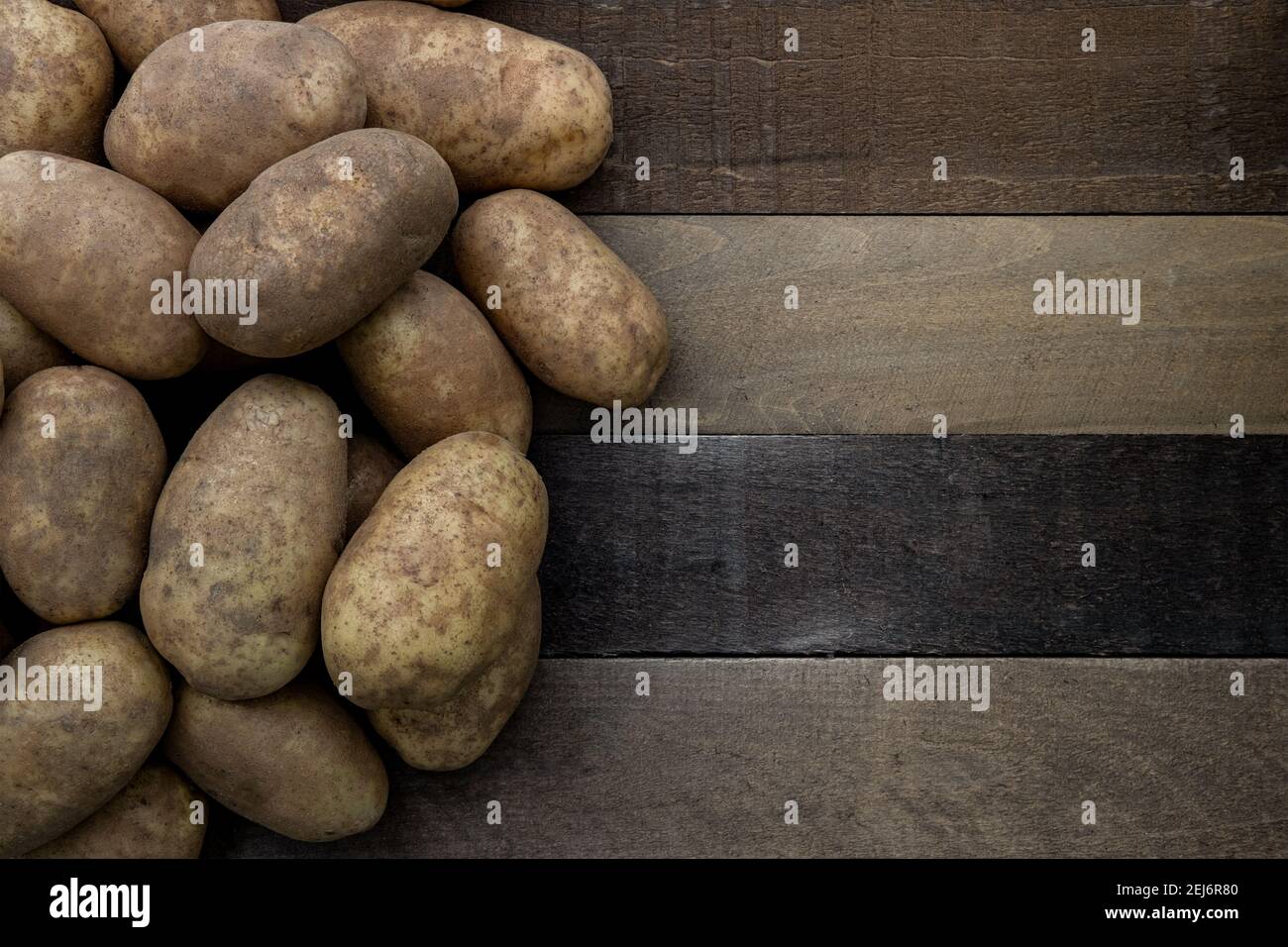 Photographie d'un tas de pommes de terre russet sur un rustique table en bois Banque D'Images