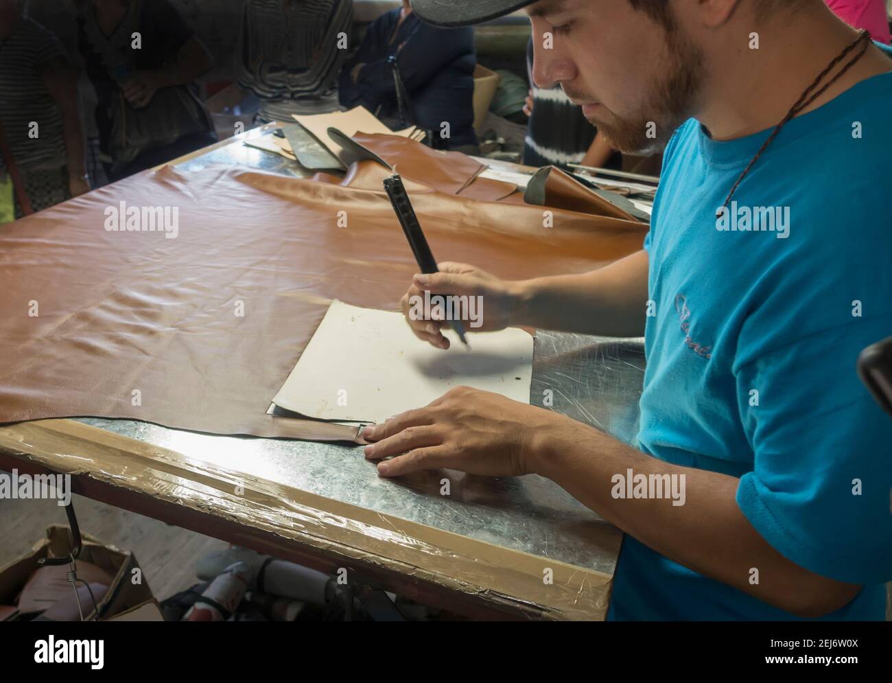 Homme utilisant le modèle pour couper le cuir pour la fabrication de sacs à main, Mexique Banque D'Images