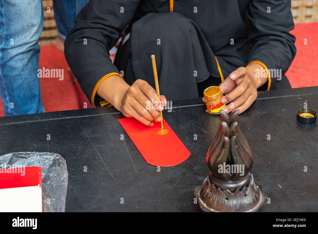 Les gens qui font l'écriture avec la calligraphie traditionnelle brosse stylo sur le chinois enveloppe de l'argent chanceux Banque D'Images