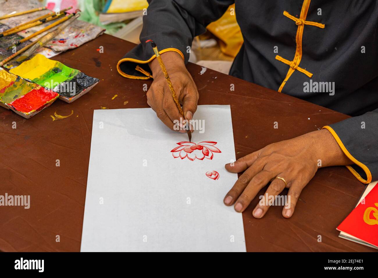 Gros plan de la main humaine à l'aide de la brosse de calligraphie chinoise peinture de fleur de lotus Banque D'Images