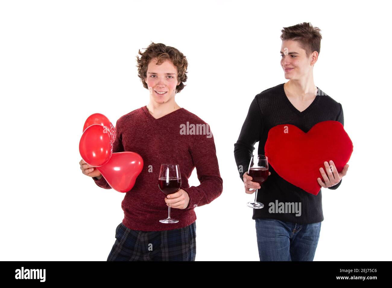 Jours fériés et week-ends. Jeune couple attrayant qui boit du vin rouge. Arrière-plan blanc. Banque D'Images