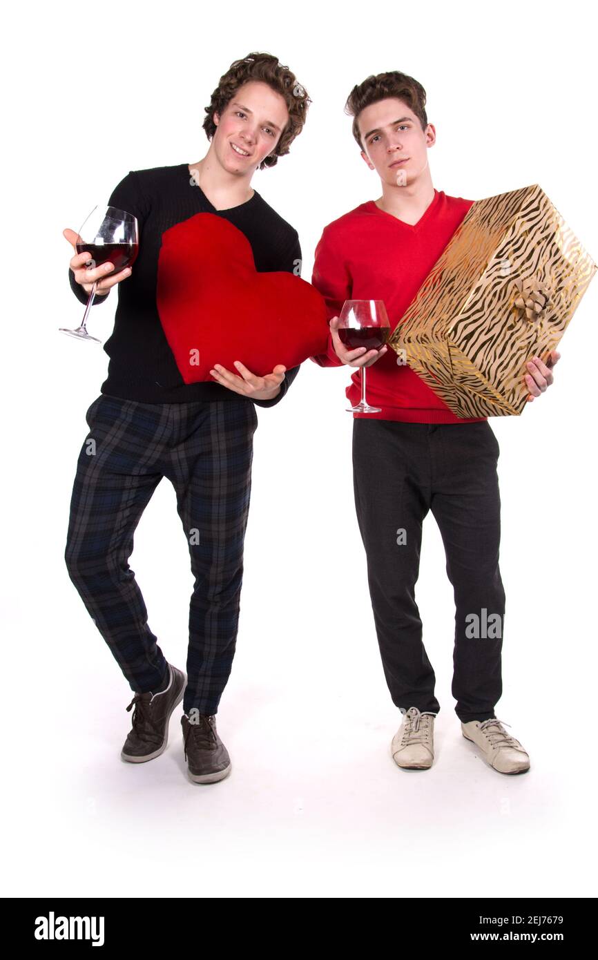 Jours fériés et week-ends. Jeune couple attrayant qui boit du vin rouge. Arrière-plan blanc. Banque D'Images