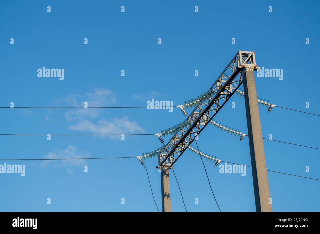 Structure de type support de deux montants en béton et barre transversale de cadre métallique avec nervures de renfort entre eux, reliant des fils électriques haute tension Banque D'Images