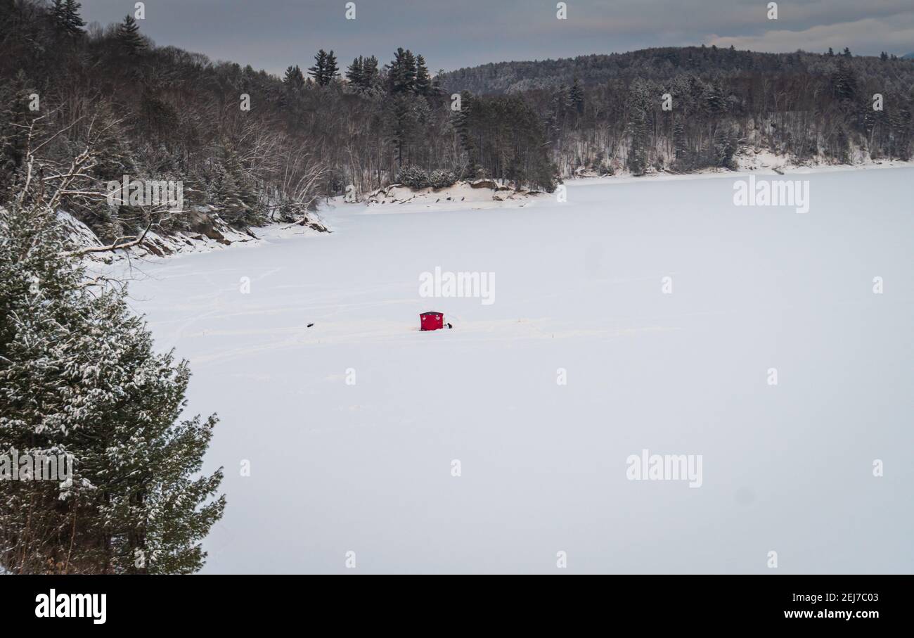 tente rouge de pêche sur glace sur un lac gelé Banque D'Images
